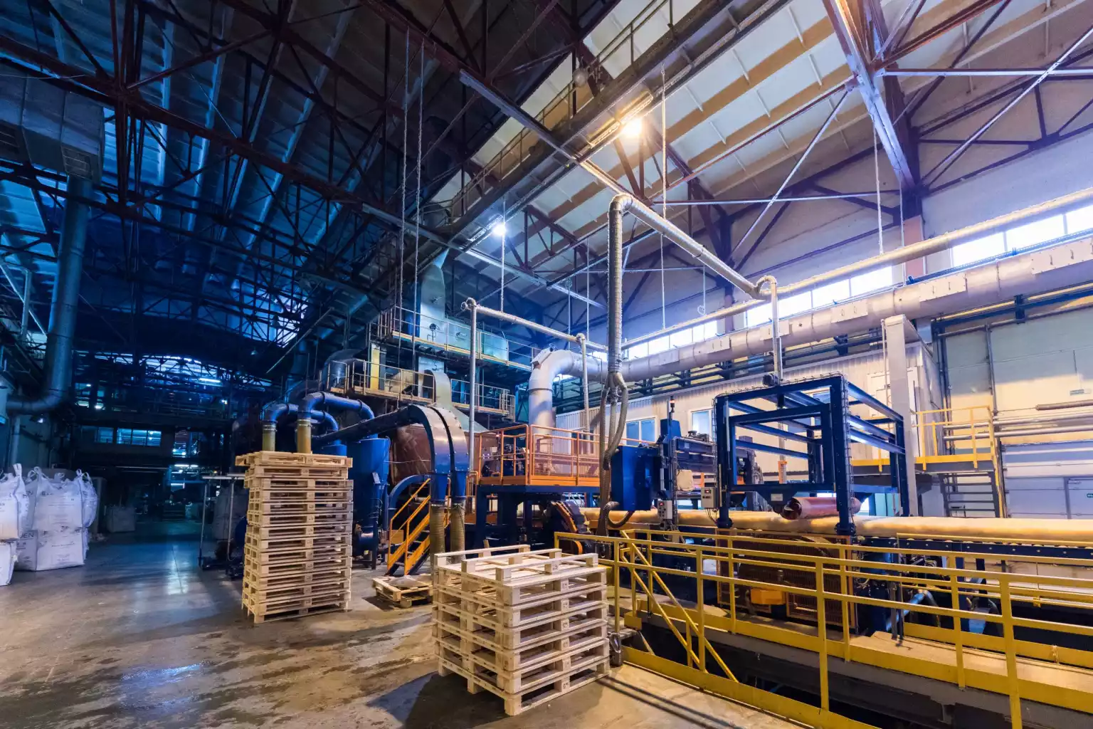 Vista ampla de galpão industrial com máquinas e linha de produção — imagem ilustrativa